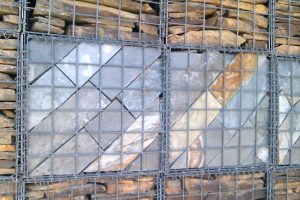 Gabion wall filled with coursed stone but a slate feature incorporated